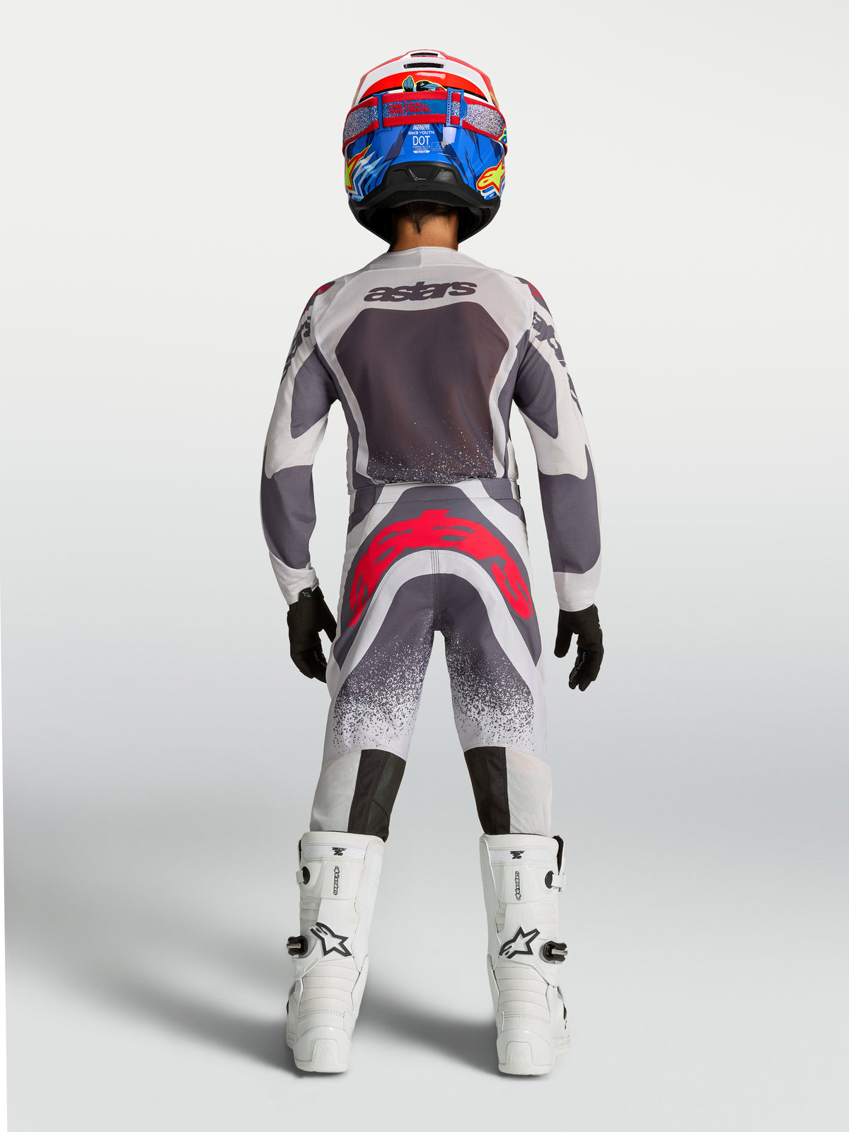 Alpinestars Youth Supertech Swan Pants, gray and red fluo youth motocross racing gear shown from the rear.
