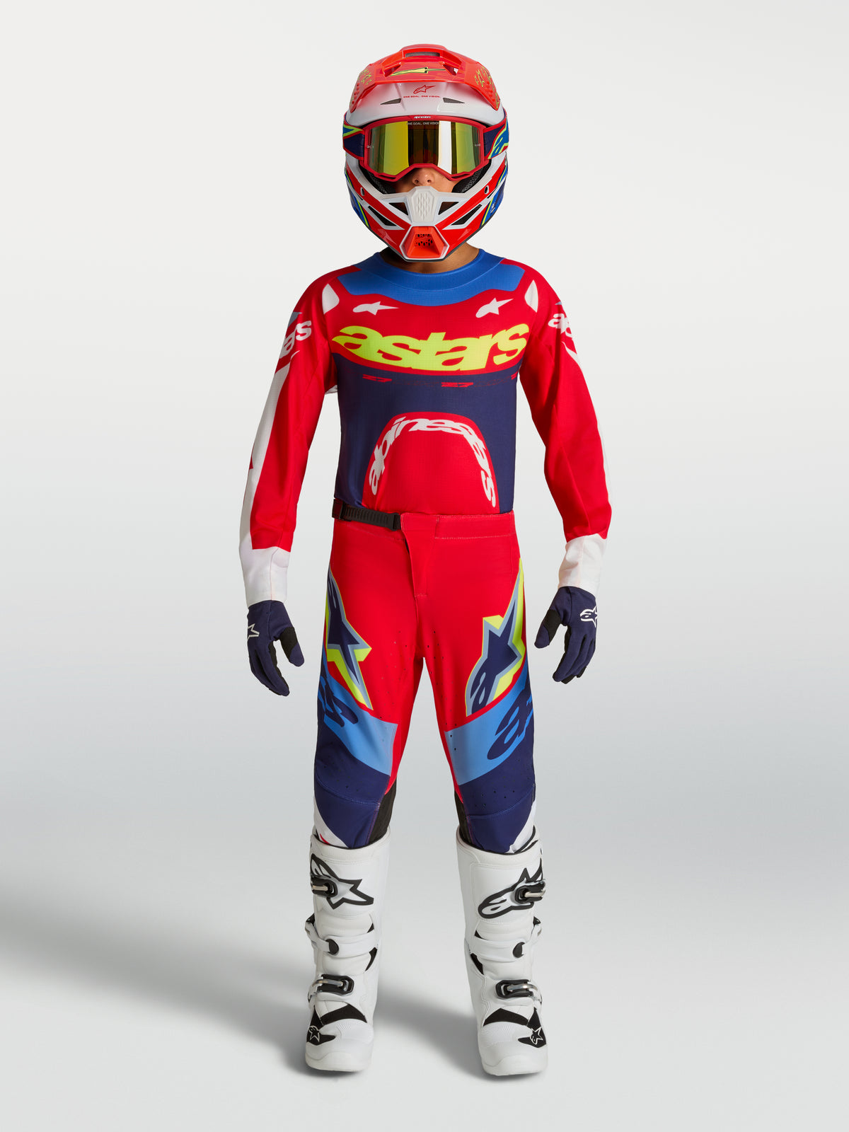 Alpinestars Youth Supertech Dyna Pants, Fire Red and Navy Blue Motocross Gear Set with White Boots and helmet.