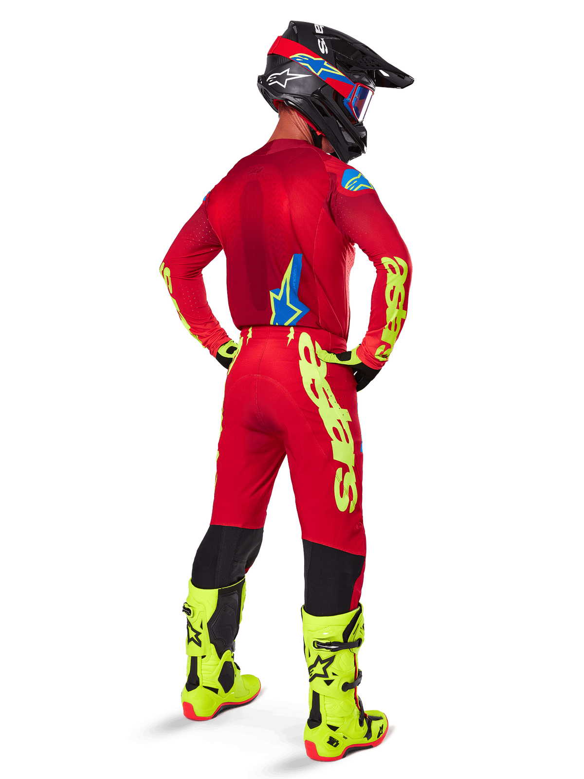 Motocross rider from a rear view wearing the Alpinestars 2025 Supertech Maker Gear Set, Bright Red jersey with yellow fluo branding, matching red pants with yellow accents, black helmet with red and blue details, fluo yellow boots, coordinated professional racing outfit for off-road performance.