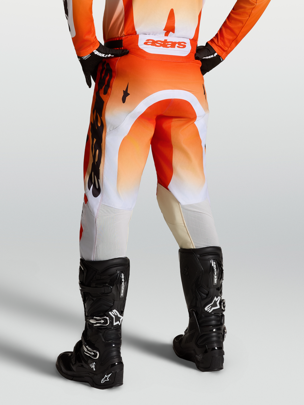 Alpinestars Racer Amber Pants, Men's Motocross Pants in Red and White with black boots, featuring durable 600D polyfabric and pre-curved race fit.