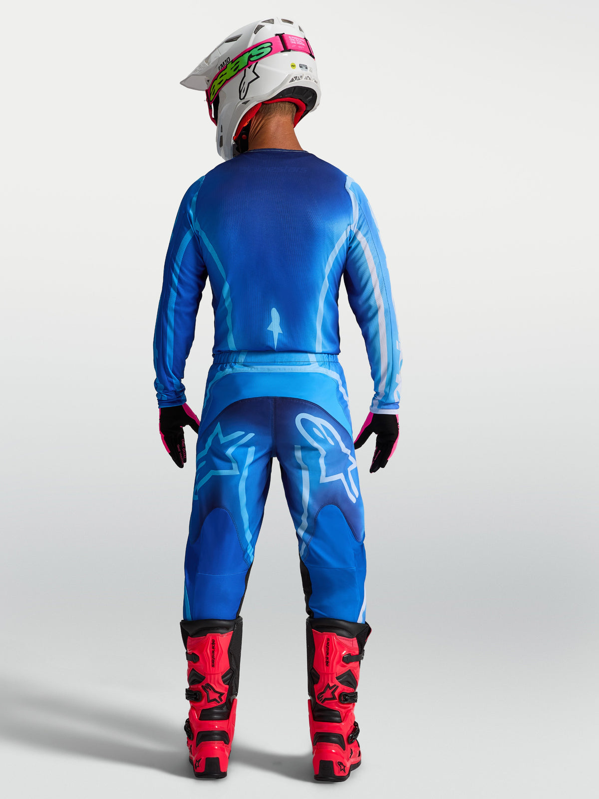 Alpinestars 2027 Fluid Kepler Jersey, blue motocross gear for men, back view on-model with matching pants and red boots.