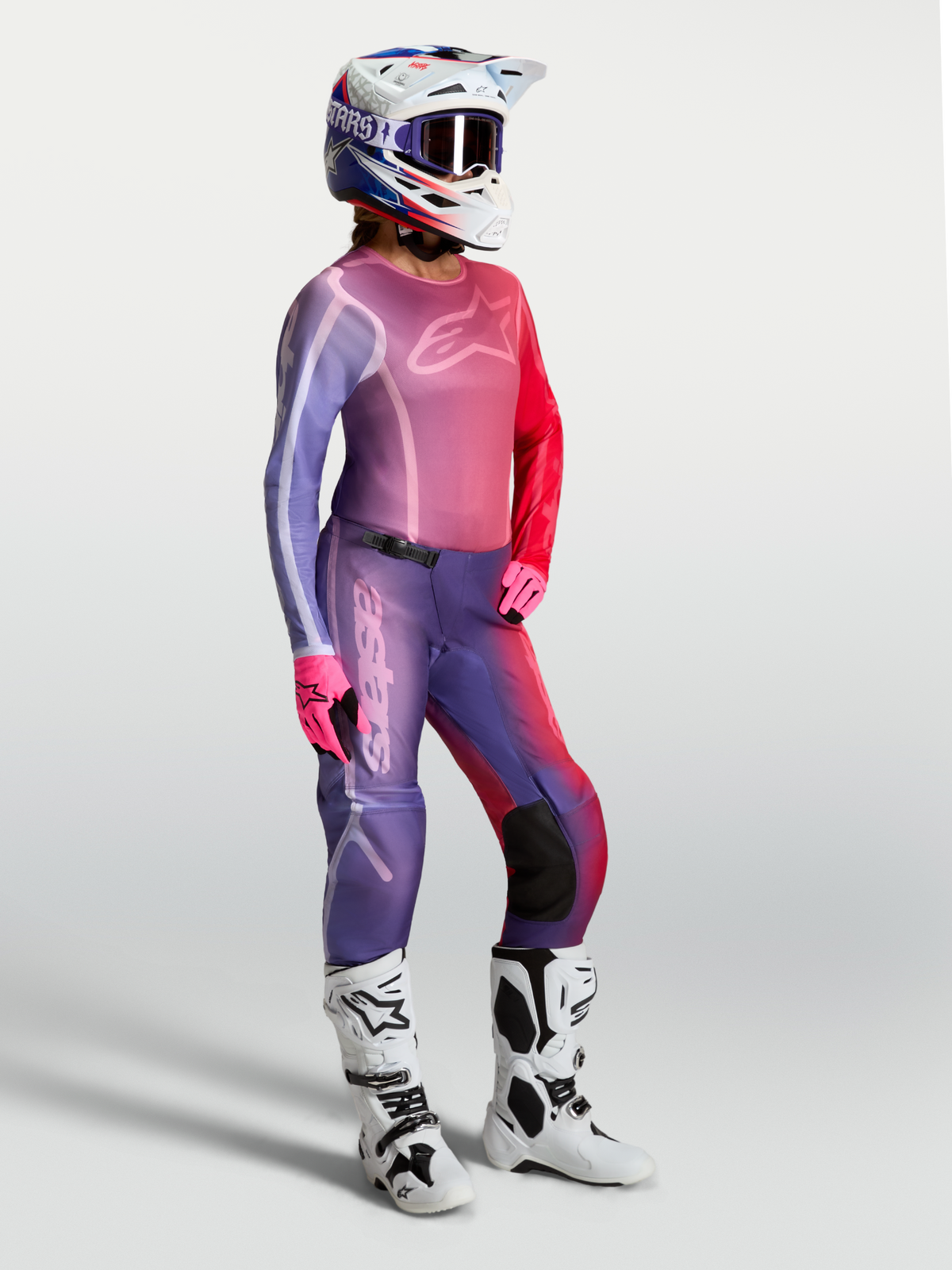 Alpinestars Stella Fluid Kepler Jersey, women's motocross top in Purple and Rouge Red, worn with matching pants and white boots.
