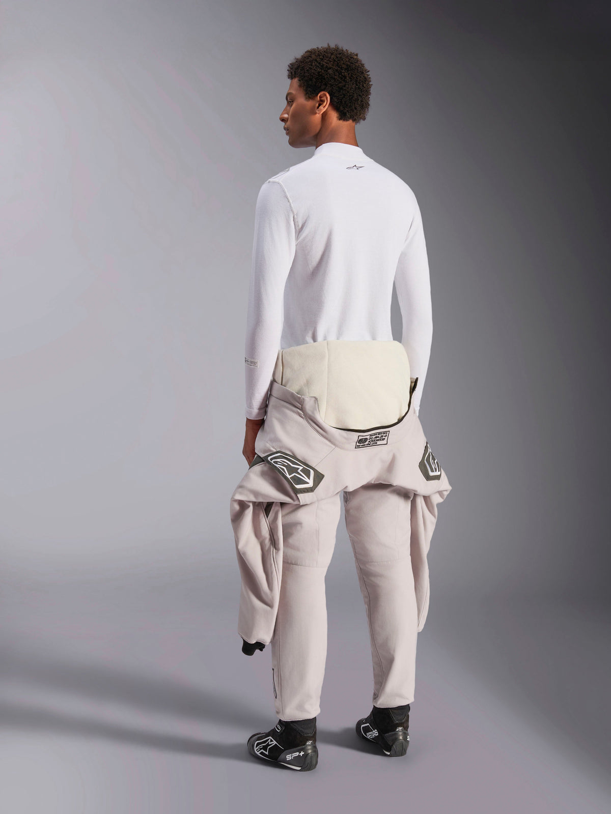 Alpinestars ZX Evo V3 Long Sleeve Top, White, rear view of a model wearing the lightweight flame-resistant base layer with a racing suit tied around the waist, professional motorsport gear for auto racing.