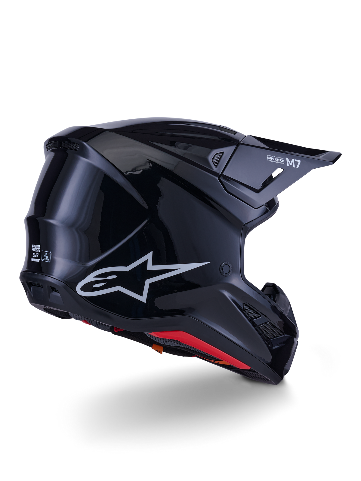 Alpinestars S-M7 Solid Helmet, Motocross Helmet, Glossy Black, featuring a sleek aerodynamic shell with a silver Astars logo, red interior trim, and integrated ventilation ports, designed for off-road racing protection
