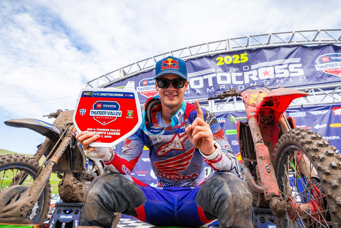 Motocross champion Jett Lawrence celebrating a win wearing an Alpinestars blue and red jersey.