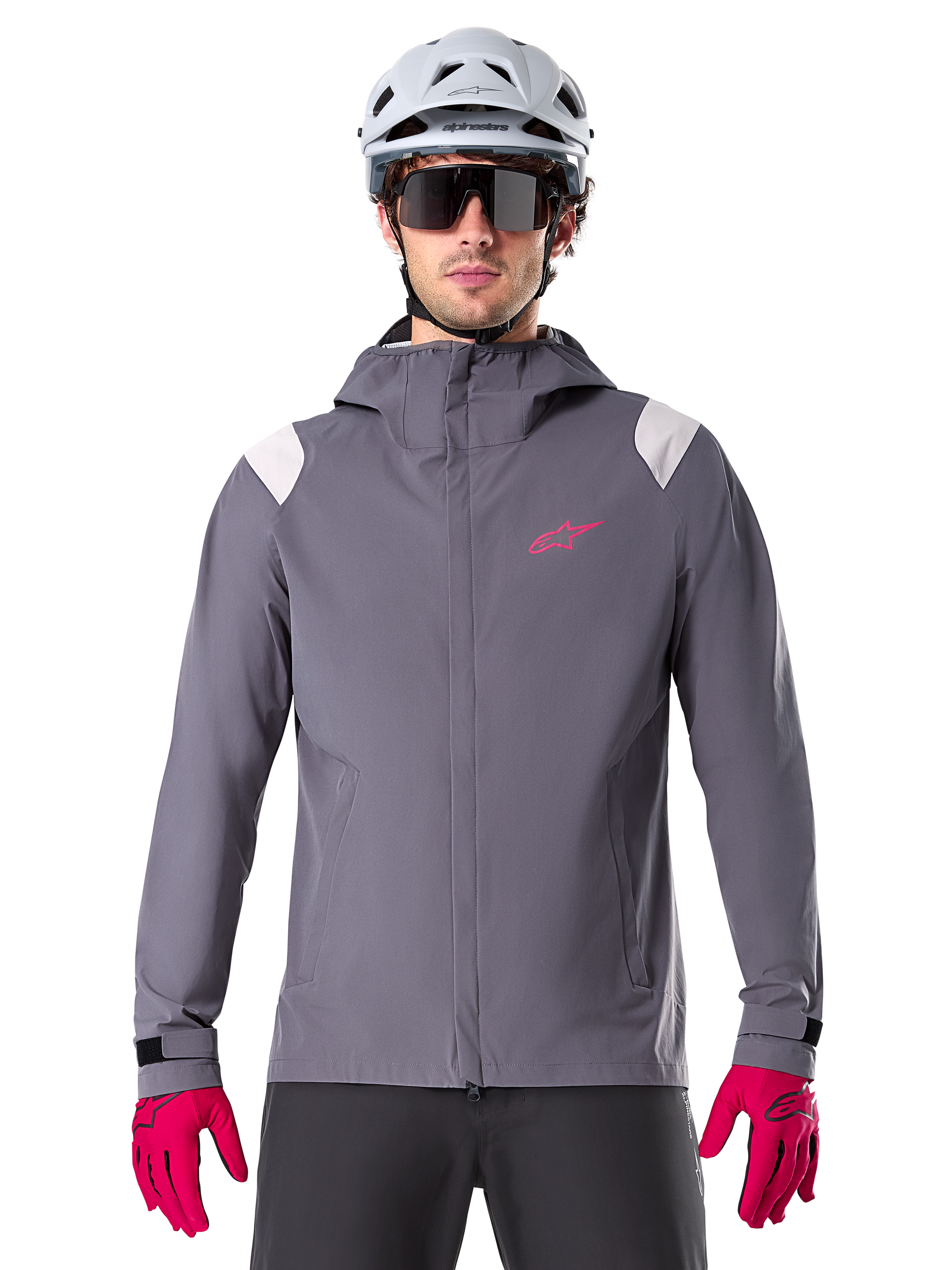 Alpinestars A-Dura Rain Jacket, Mountain Bike Rain Jacket, Dark Titanium Gray, hooded design with pink Alpinestars logo and light gray shoulder panels, worn with white MTB helmet and bright pink gloves, waterproof gear for off-road cycling
