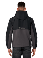 Alpinestars Juncture Hybrid Jacket, Back View, Black and Gunmetal, casual sportswear anorak with mixed material construction, ripstop upper and canvas fleece lower, Alpinestars logo on back, worn with dark pants