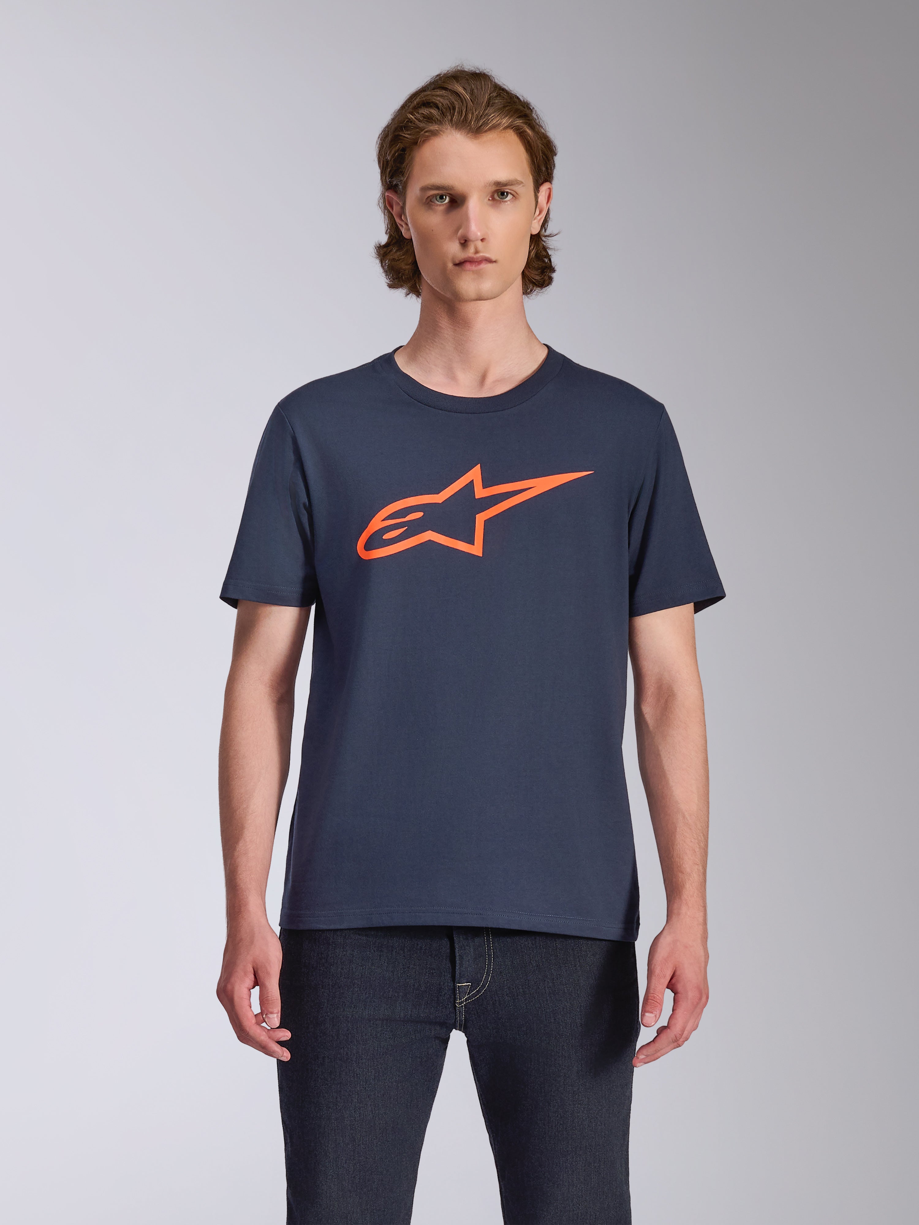 Alpinestars Ageless 2.0 CSF Tee, Short Sleeve T-Shirt, Navy Blue with Bright Orange Logo, worn with dark denim jeans, casual motorsport lifestyle apparel