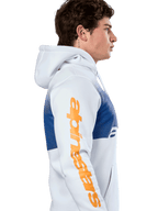 Alpinestars Specter Hoodie, casual streetwear, white with blue gradation fade print, large orange Alpinestars wordmark on sleeve, side profile of man wearing pullover hoodie