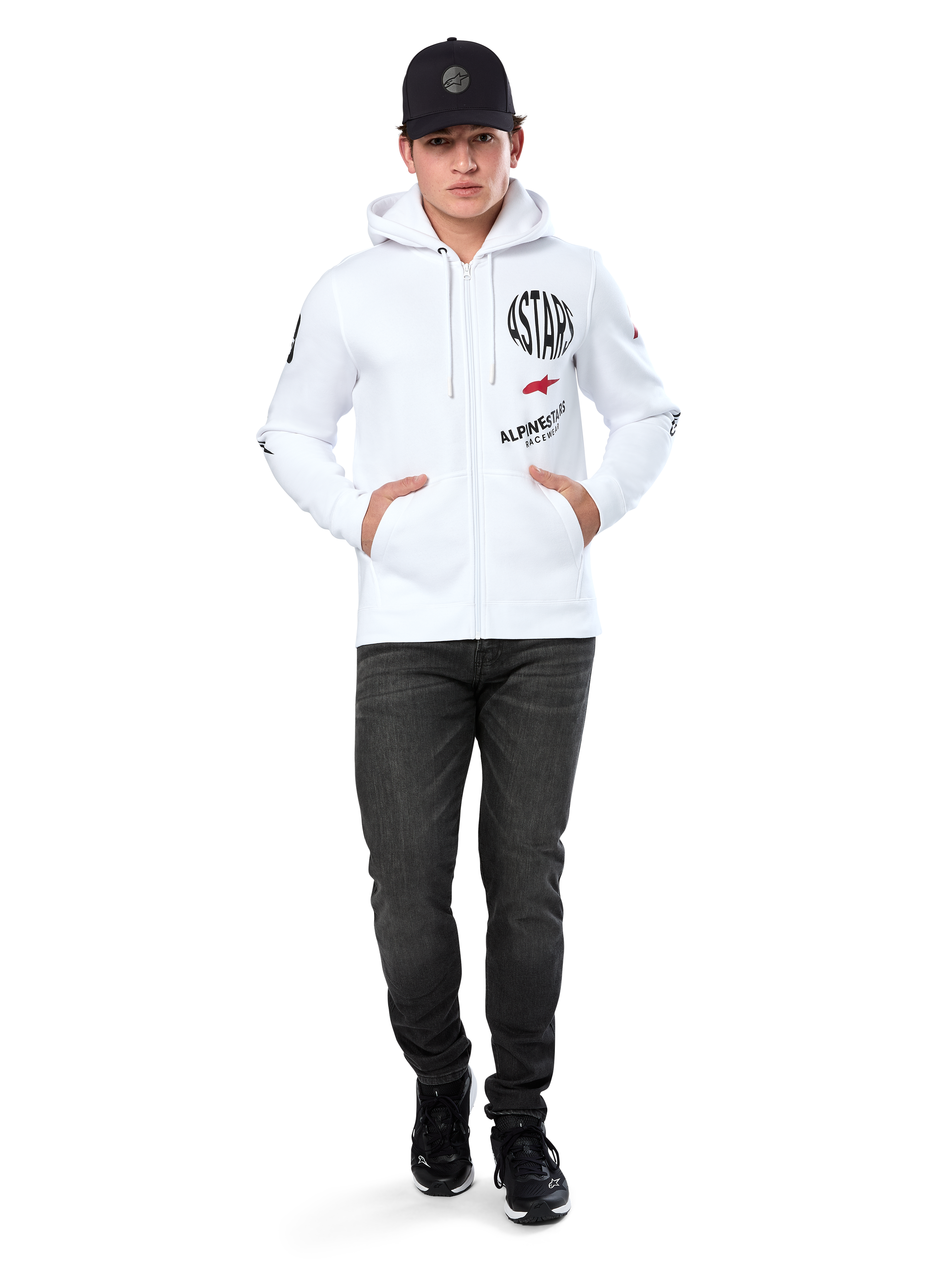 Alpinestars Variegate Hoodie, White Zip-Up Fleece Hoodie, multi-logo artwork with 'ASTARS' and red star logo on chest, graphic details on sleeves, worn by model with black cap and black jeans, casual motorsport streetwear