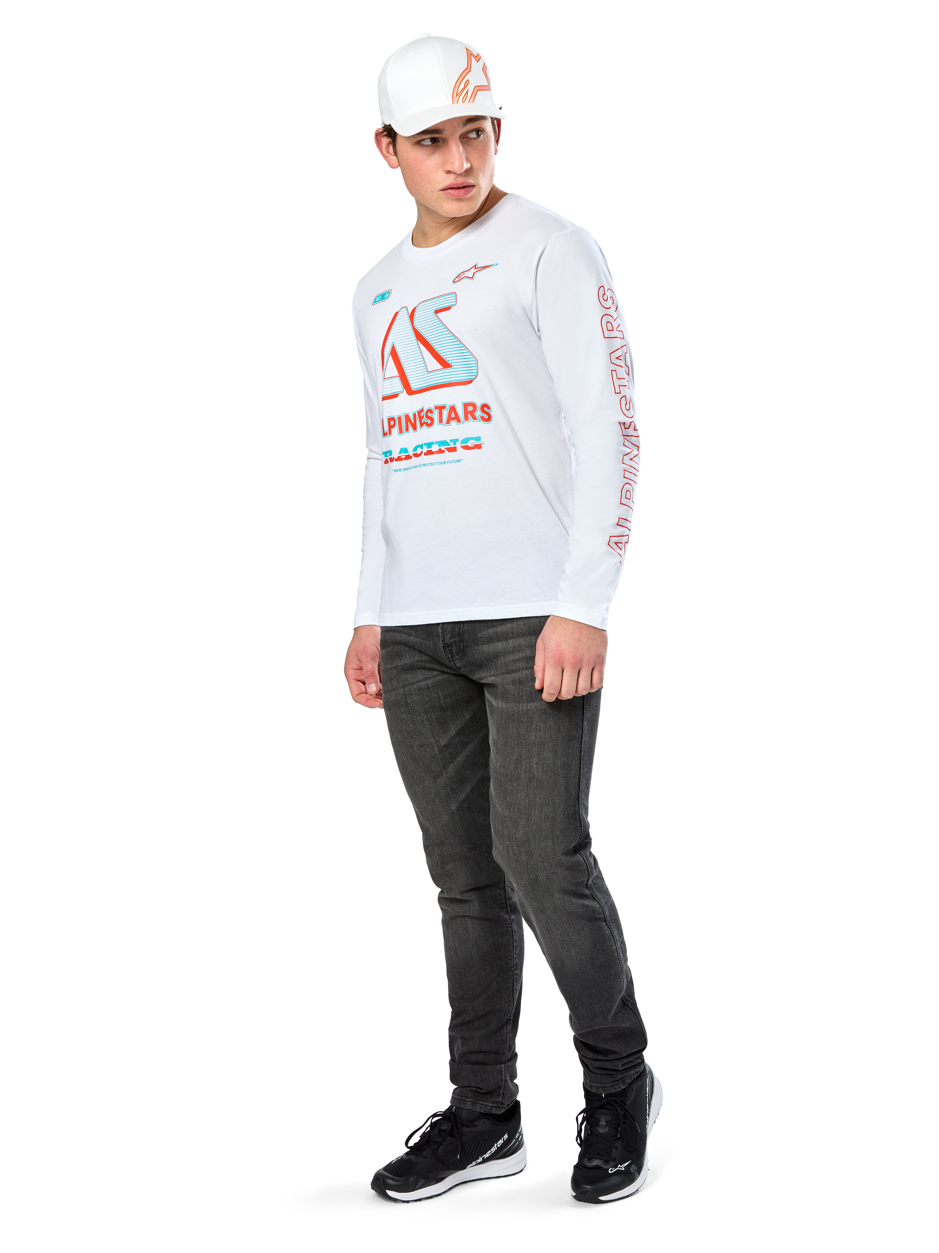 Alpinestars Ayess CSF Tee, Long Sleeve T-Shirt, White, featuring large blue and red CSF racing graphics on the chest and red Alpinestars branding on the sleeve, worn with dark jeans and a white Alpinestars cap, casual motorsport streetwear