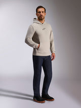 Alpinestars Insight Hoodie, casual streetwear, Cement gray with black Astars logo on chest, pullover design with kangaroo pocket, worn with dark blue jeans and black sneakers, modern motorsport-inspired style