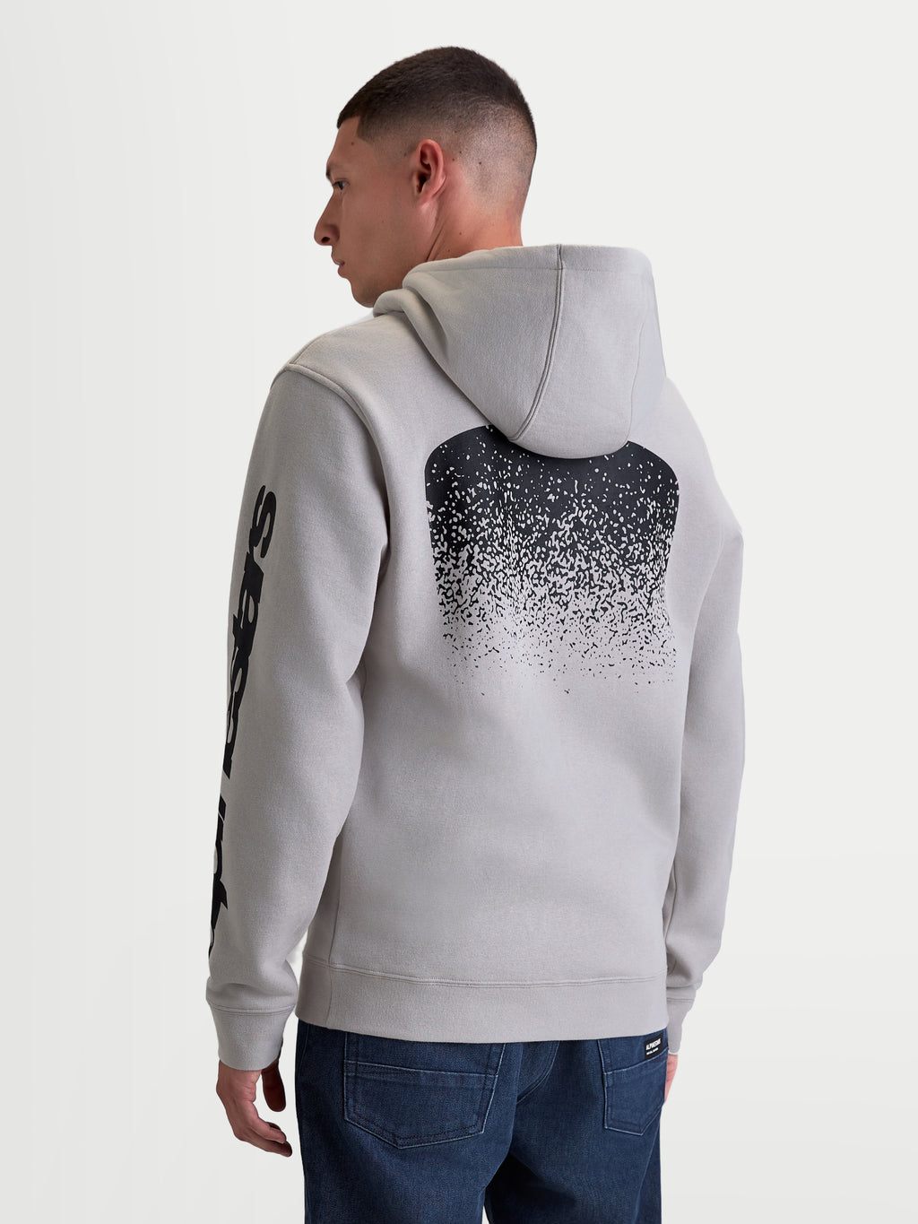 Alpinestars Obsessed Hoodie, Men's Sportswear Pullover Fleece in Cement Gray, Featuring a Large Black MX-Inspired Gradient Back Graphic and Sleeve Branding, Rear View on Model, Casual Motorsport Lifestyle Apparel.