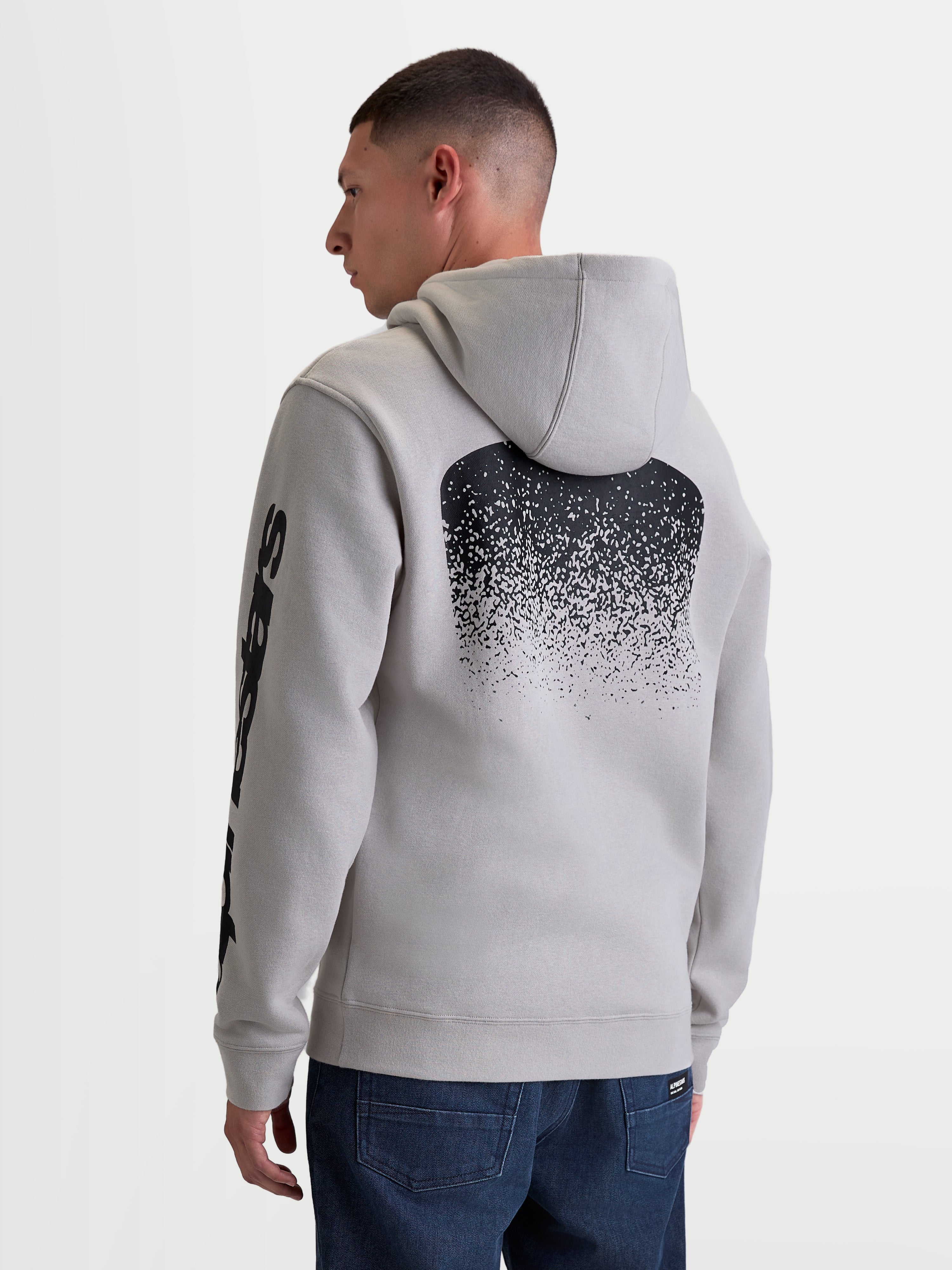 Alpinestars Obsessed Hoodie, Men's Sportswear Pullover Fleece in Cement Gray, Featuring a Large Black MX-Inspired Gradient Back Graphic and Sleeve Branding, Rear View on Model, Casual Motorsport Lifestyle Apparel.
