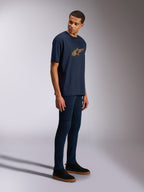 Alpinestars Alter Oversized CSF Tee, Short Sleeve T-Shirt, Navy Blue, Yellow and Orange Astars logo, worn by a model with dark jeans and black sneakers, casual motorsport-inspired streetwear
