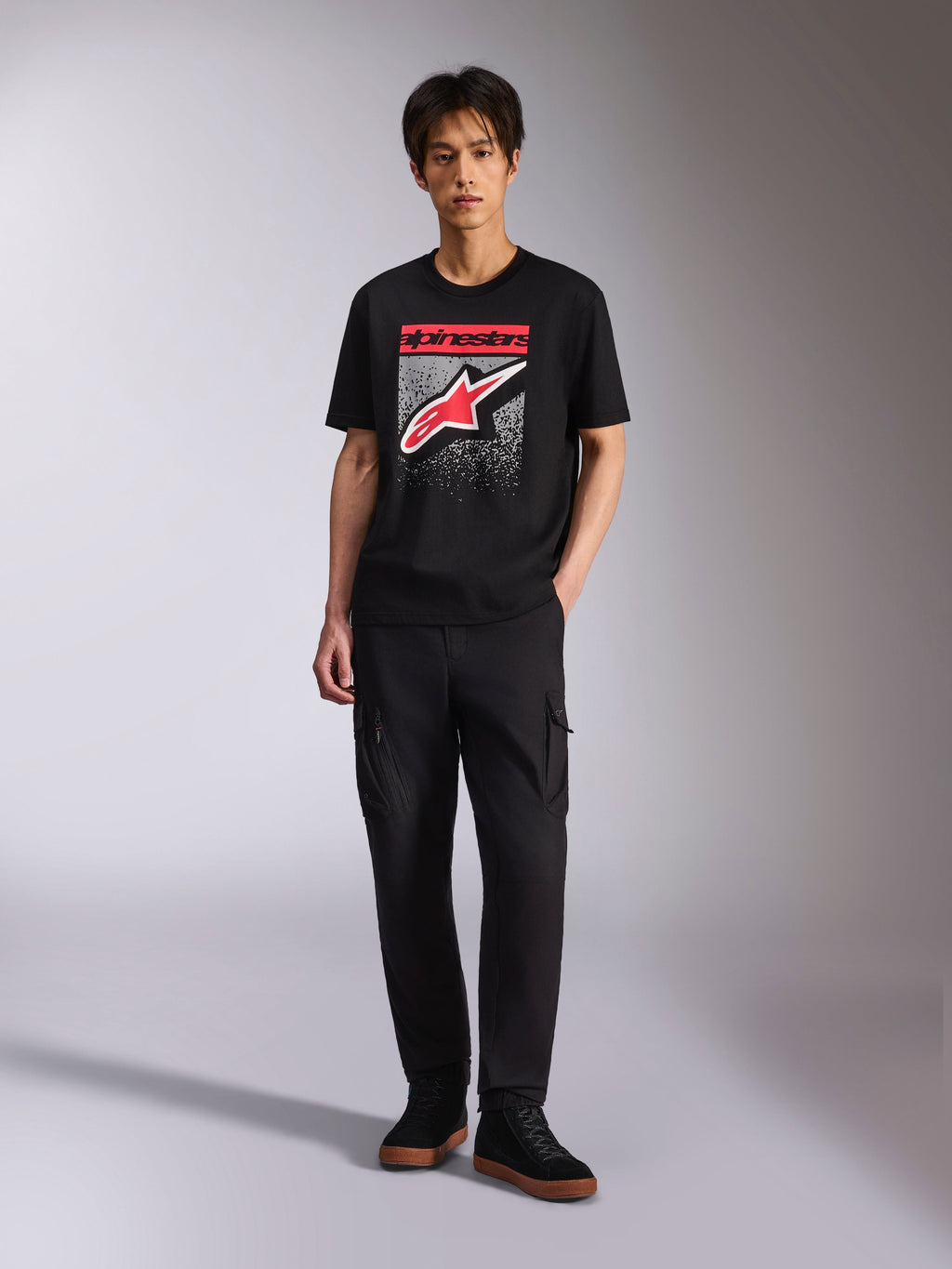 Alpinestars Noka CSF Tee, Short Sleeve T-Shirt, Black, Front Astars Logo with red and white MX gradation graphic, worn by a model with black cargo pants, Casual Motorsport Streetwear