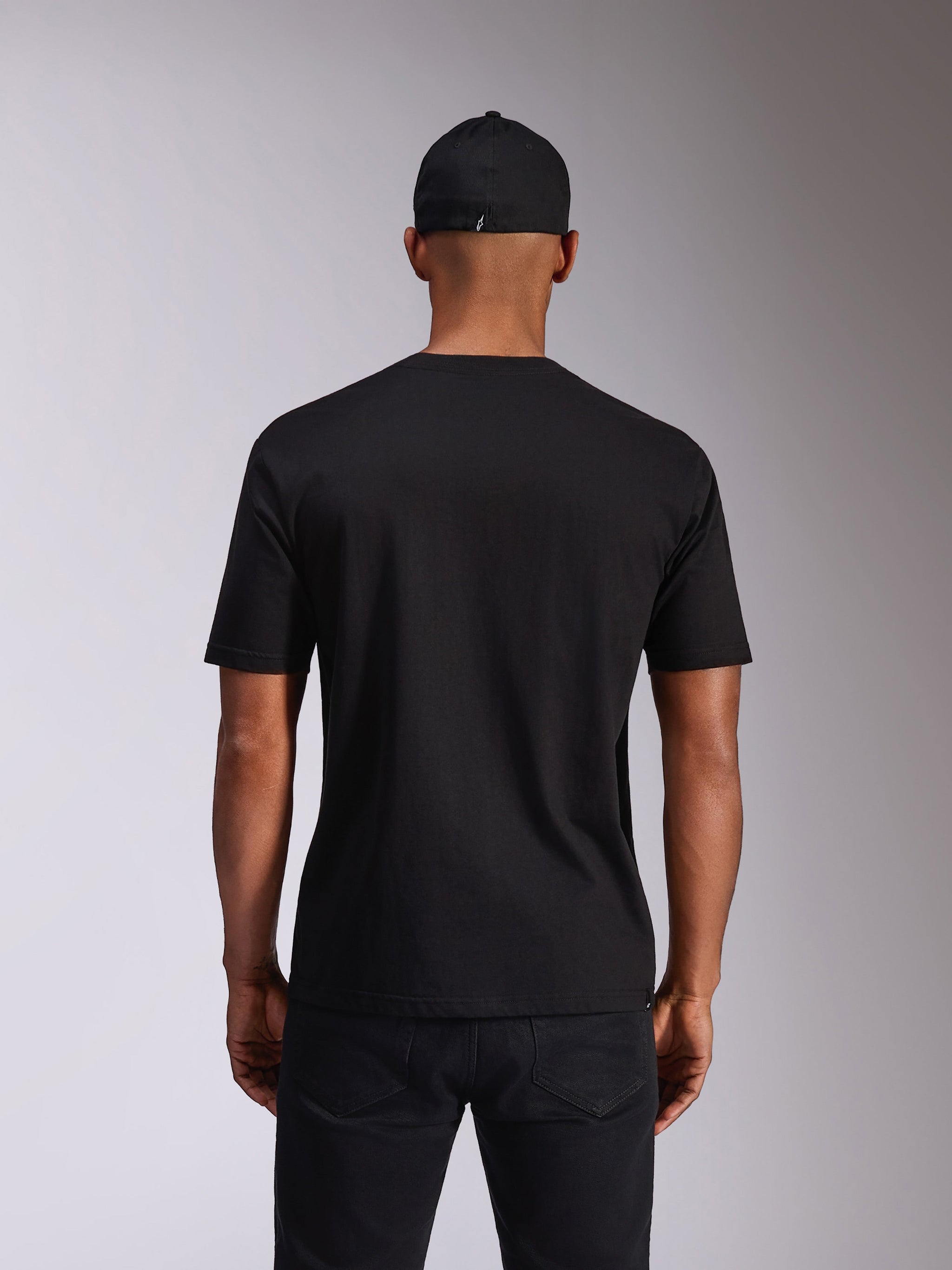Alpinestars Ellipsoid CSF Tee, Short Sleeve T-Shirt, Black, Back view on model, worn with a black cap and dark trousers, casual motorsport-inspired streetwear