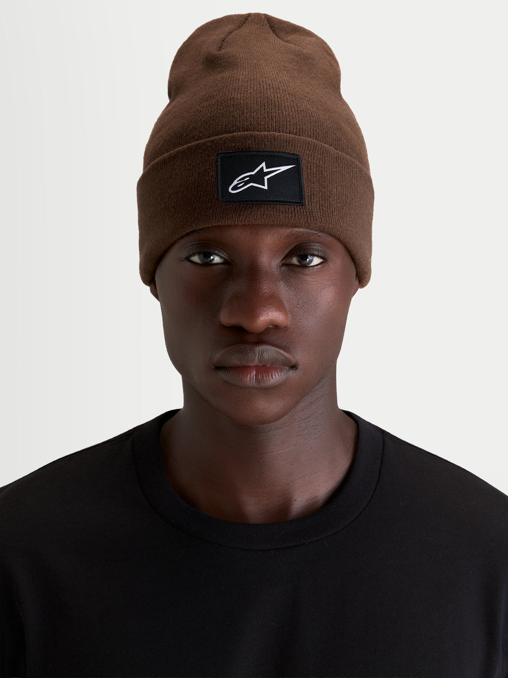 Alpinestars Augment Cuff Beanie, sportswear beanie hat in brown featuring a woven Alpinestars logo patch on the cuff, worn by a model in a black t-shirt