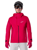 Alpinestars A-Dura Elite Waterproof Jacket, Mountain Bike Rain Jacket, Red Fluo, high collar with white Alpinestars logo, black zipper details, worn with matching gloves and black cycling helmet, technical waterproof cycling gear