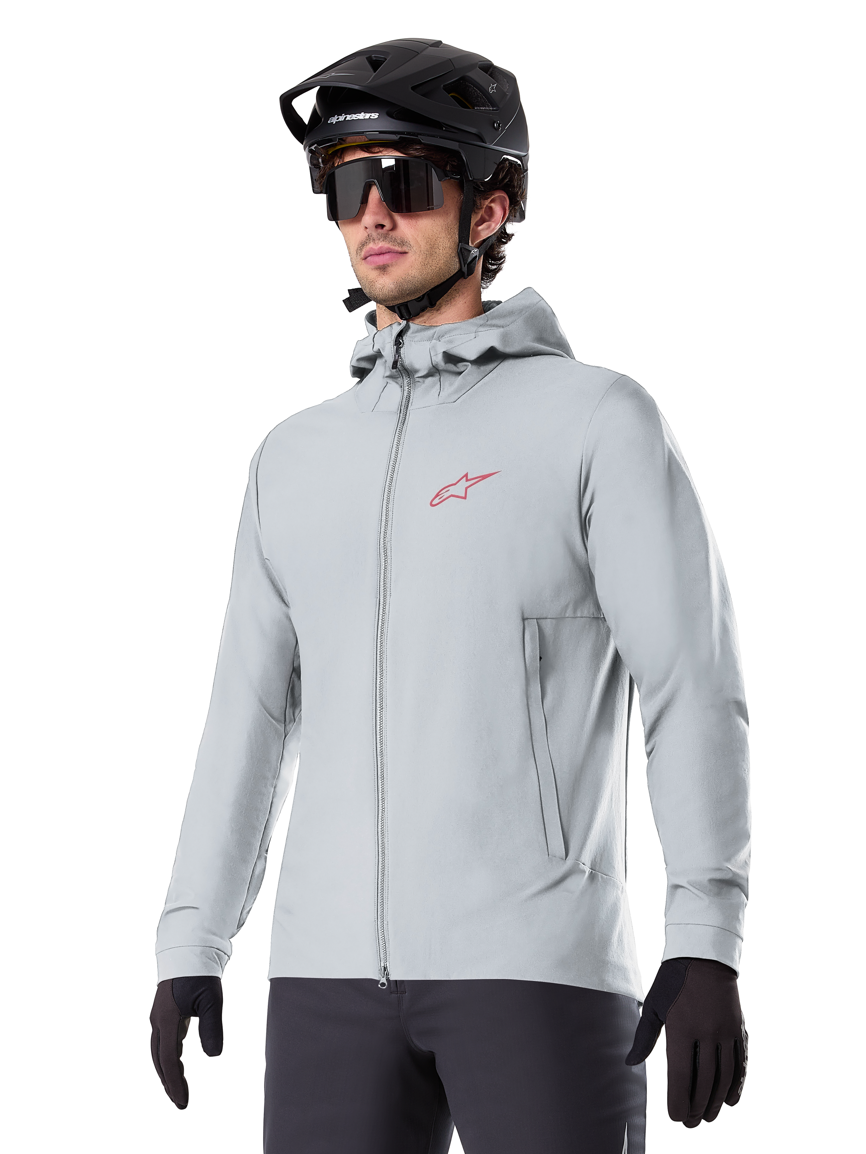Alpinestars A-Dura Thermal Jacket, light gray insulated cycling jacket, hooded design with a small red logo, worn with a black helmet and gloves, technical mountain bike apparel for cold-weather riding