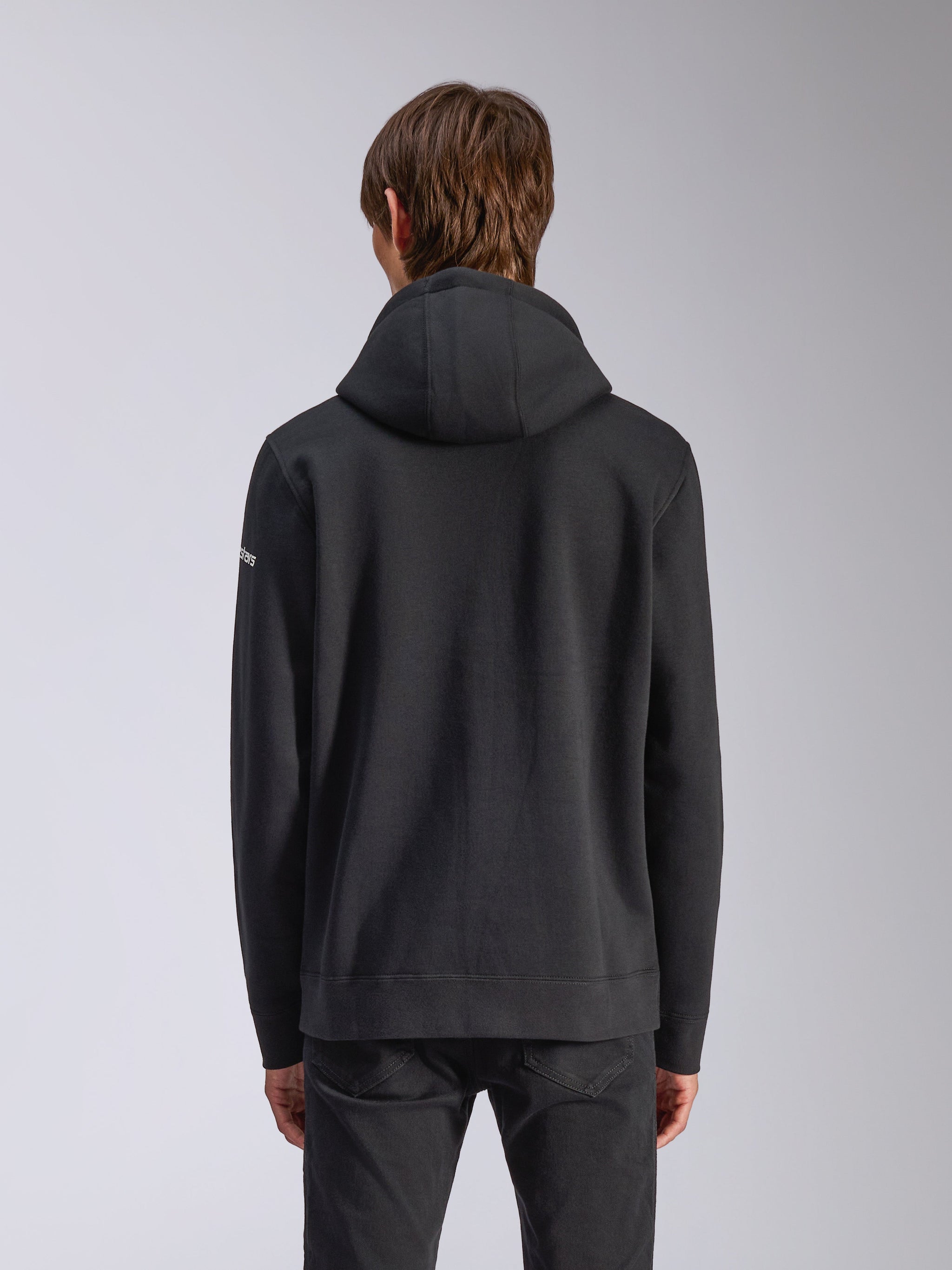 Alpinestars Frontal Hoodie, Black, back view of a casual pullover sweatshirt, featuring a self-lined hood, ribbed hem, and white wordmark logo on the sleeve, motorsport-inspired streetwear.