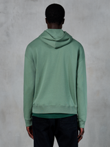 Alpinestars Essentials Ageless Hoodie, casual sportswear, Cactus green, rear view on model, garment stone wash finish, paired with black pants, minimalist lifestyle design