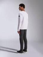 Alpinestars Bettern Crew, White Crewneck Sweatshirt, back and side view, black circular logo on the sleeve, worn with dark grey pants and black sneakers, casual motorsport lifestyle streetwear