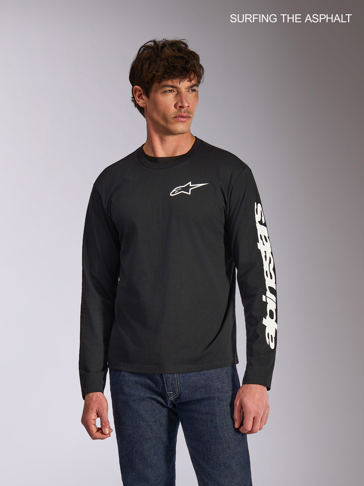 Alpinestars Trackside CSF Long Sleeve T-Shirt, men's casual long sleeve tee in black, featuring a white Ride 4.0 logo on the front and printed branding on the sleeve, worn by a model with jeans