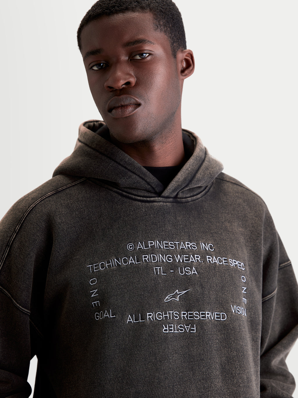 Alpinestars Infinite Washed Oversized Hoodie, Men's Casual Sportswear Pullover, Washed Black Snow-Wash Finish, Front view on model showing white embroidered chest graphic and relaxed fit.