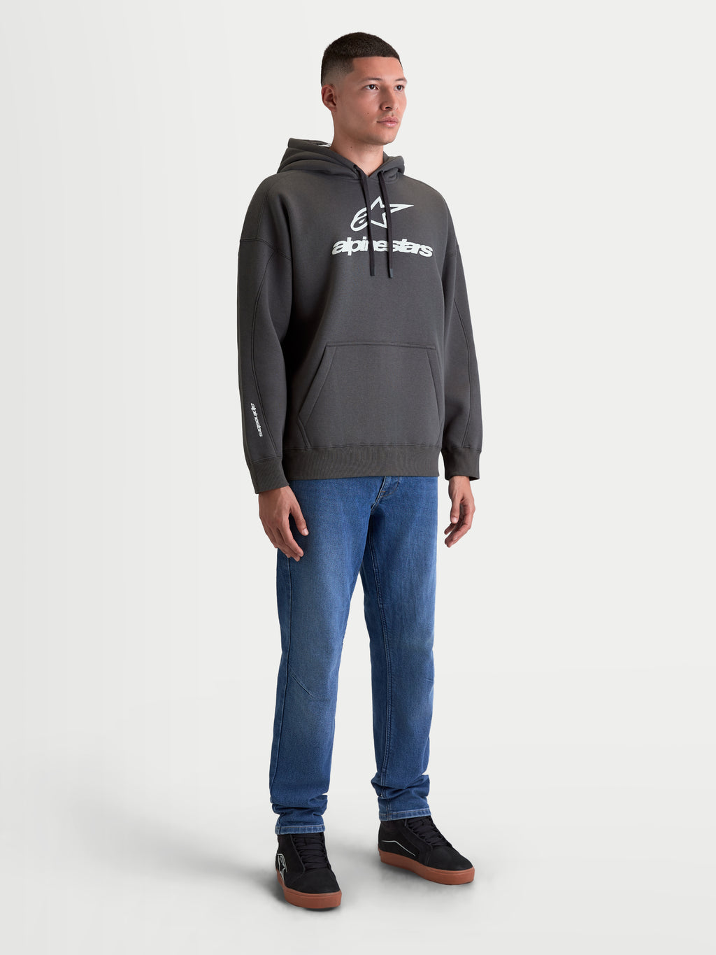 Alpinestars Prelude Oversized Hoodie, Premium Sportswear Fleece Pullover in Charcoal Gray, featuring a bold white puff-print logo, kangaroo pocket, and relaxed oversized fit, shown on-model for a casual lifestyle look.