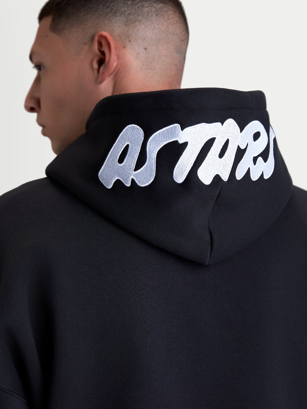Alpinestars Pioneer Oversized Hoodie, Casual Sportswear Zip Fleece, Black with White Embroidered ASTARS Logo on Hood, Close-up Back View, Premium Cotton Blend Construction