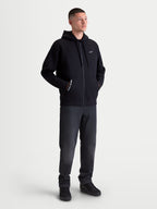 Alpinestars Pioneer Oversized Hoodie, Sportswear Full-Zip Fleece for Men and Women, Black, Cotton-Rich Blend, featuring a Vislon zipper, kangaroo pocket with 'ONE GOAL. ONE VISION.' branding, and white Astars chest logo. On-model view showing the relaxed oversized fit designed for casual everyday wear.