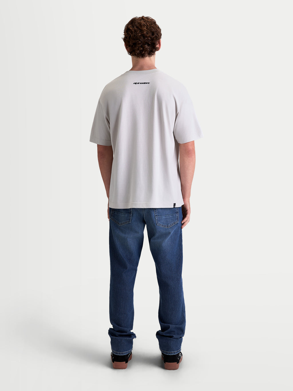 Alpinestars Prelude Oversized CSF Tee, Men's Short Sleeve Sportswear T-Shirt, Cement Gray, back view on model featuring a small black Alpinestars word logo and a relaxed oversized fit, premium cotton-poly blend construction for off-bike style.