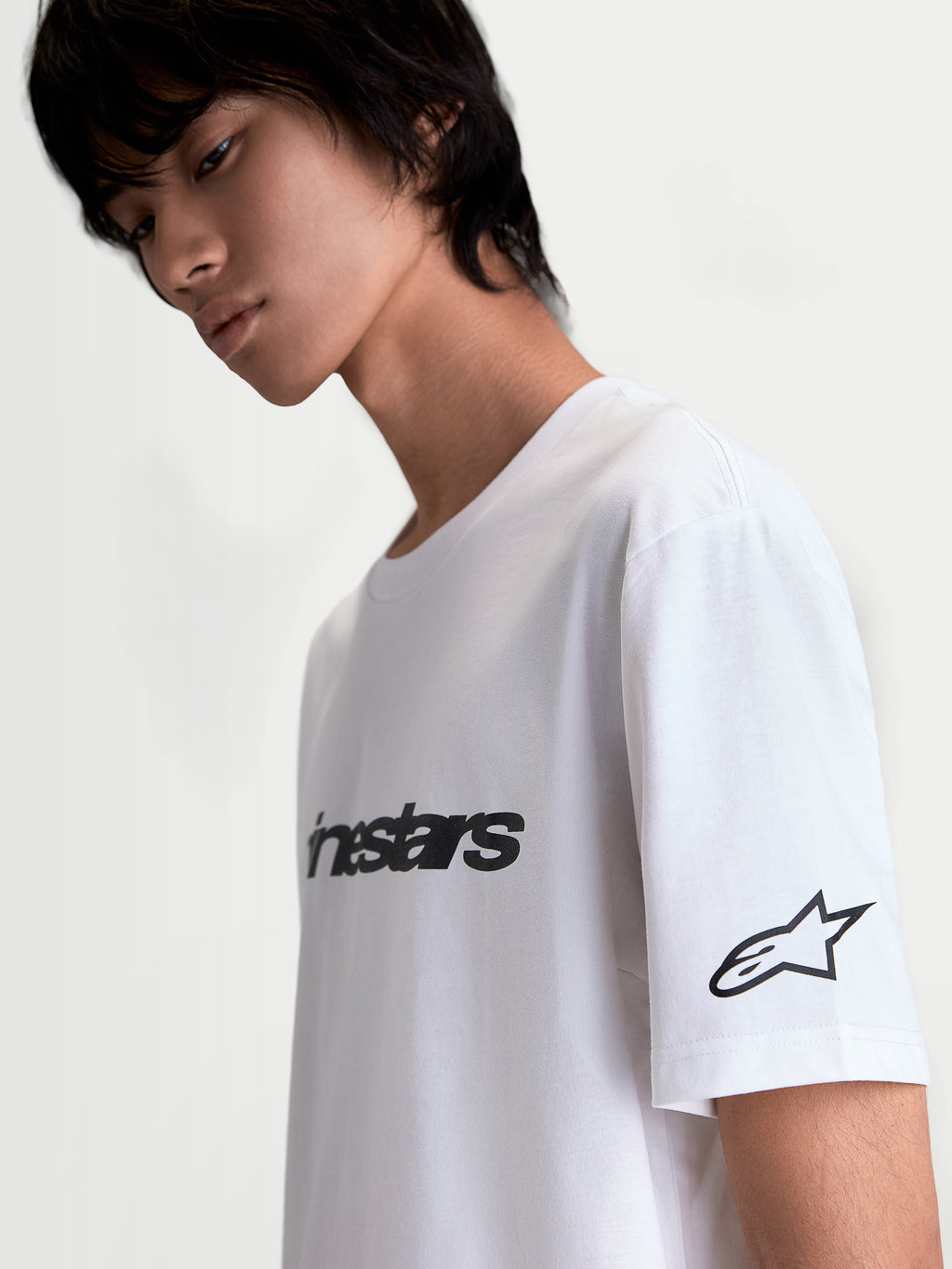 Alpinestars Race Wordmark CSF Tee, White and Black Casual Sportswear Short Sleeve T-Shirt, featuring a bold front wordmark and Ageless star logo on the sleeve, soft-hand graphic print, cotton-poly blend, on-model side view.