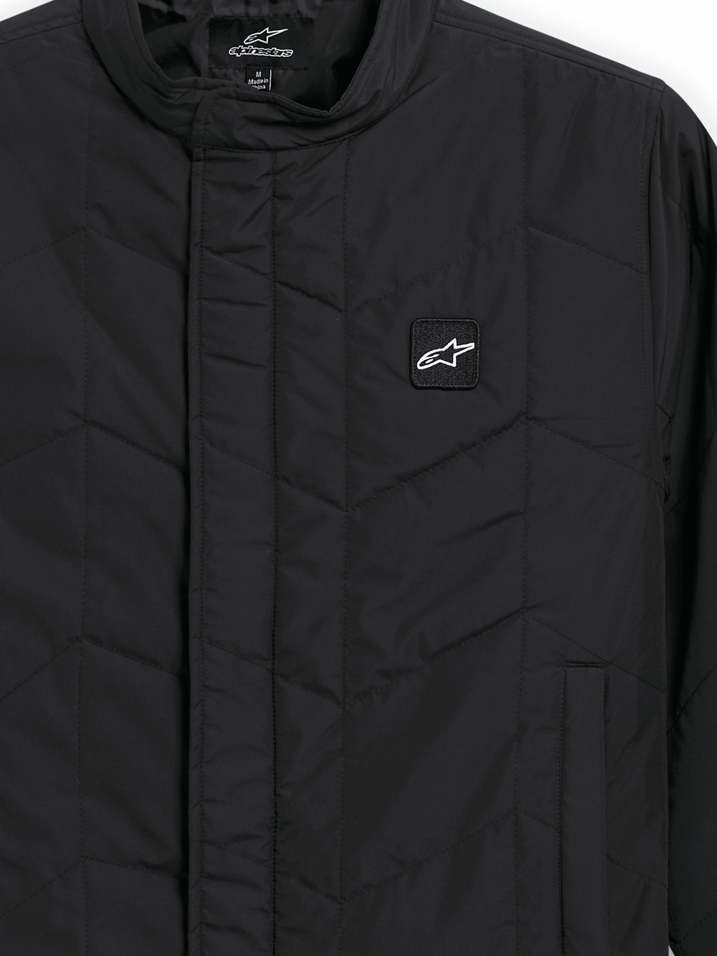 Alpinestars Precedent Jacket, Quilted Sportswear Jacket, Black, close-up view featuring an iconic angled quilt pattern, low track collar, covered front zipper, and small chest logo patch