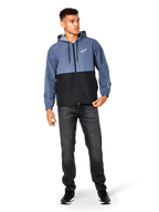 Alpinestars Speeder Windbreaker Jacket, Slate Blue and Black, hooded lightweight jacket with mesh lining, white star logo on chest, worn with black jeans and sneakers, casual motorsport streetwear design.