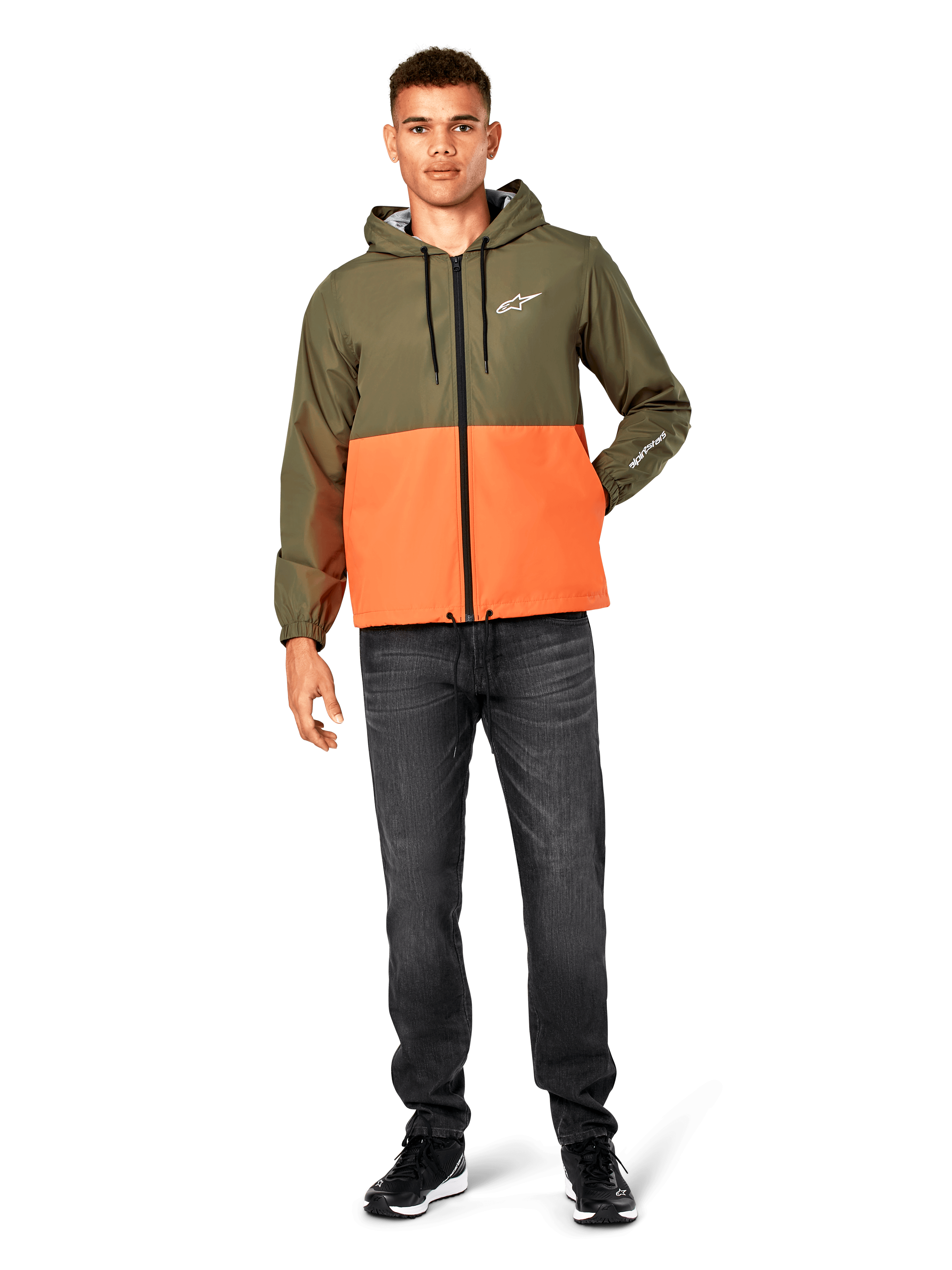 Alpinestars Speeder Windbreaker Jacket, color-blocked Military Green and Orange, lightweight hooded jacket with black drawcords and front zipper, white logo on chest and sleeve, worn with dark jeans and black sneakers, casual sportswear style.