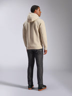 Alpinestars Ageless V3 Hoodie, casual off-white hooded pullover fleece shown from the back, features ribbed cuffs and hem, worn with dark slim-fit jeans and black Alpinestars sneakers