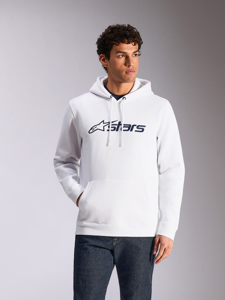 Alpinestars Blaze V3 Hoodie, casual streetwear, white with navy blue Alpinestars logo, drawstring hood, long sleeves, worn with dark denim jeans, modern motorsport-inspired design