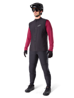 Alpinestars A-Dura Thermal Vest, Black cycling vest, worn by a rider over a maroon long-sleeve jersey and black pants, featuring a black MTB helmet and gloves, designed for cold-weather mountain biking