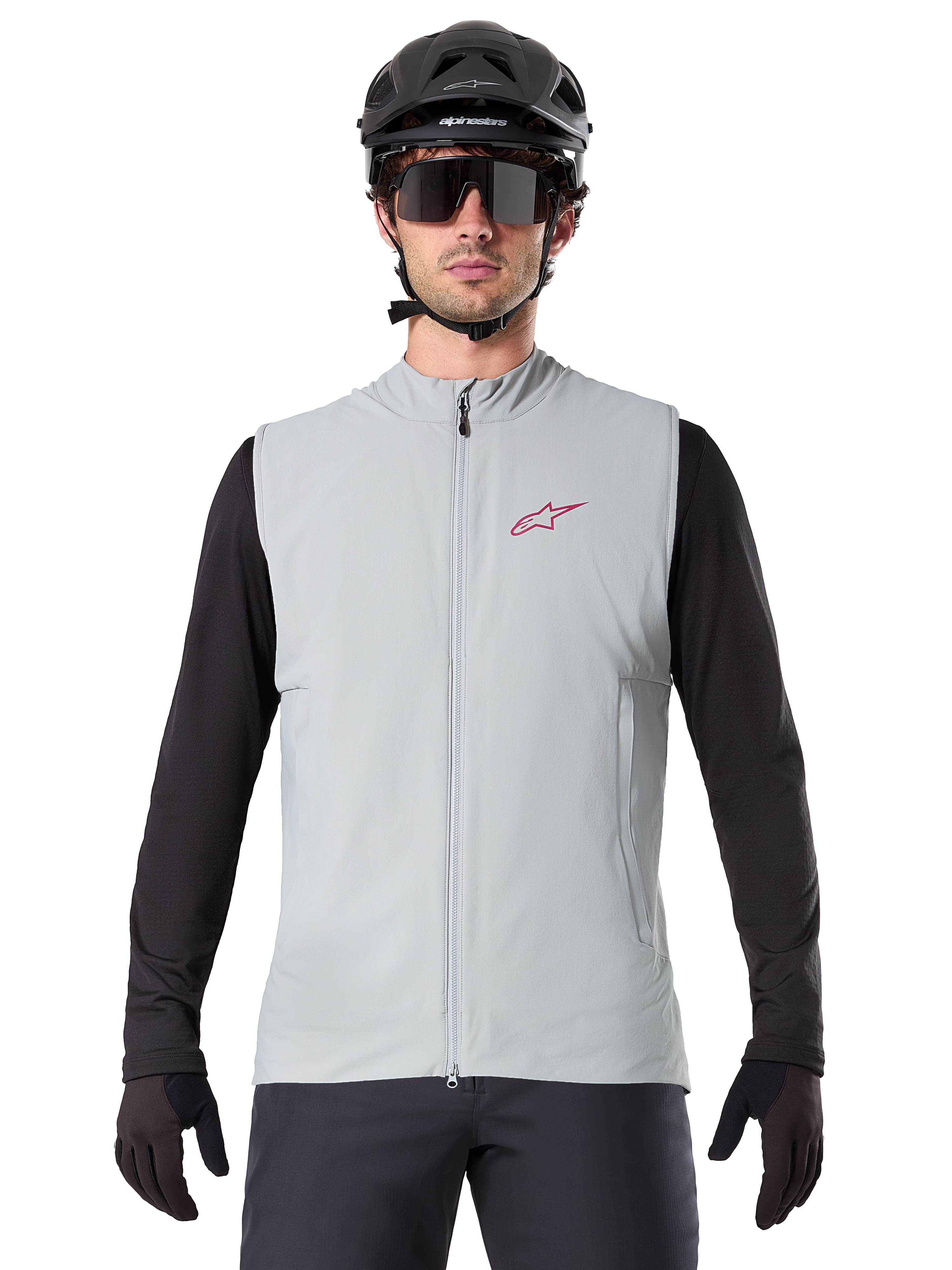 Alpinestars A-Dura Thermal Vest, Cycling Gilet, Titanium Gray, worn with a black long-sleeve jersey and black cycling helmet, red Alpinestars star logo on chest, lightweight and insulated for mountain biking.