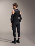 Male model from the back wearing Alpinestars A-Motion Plasma Protection Vest, Black Camo, sleeveless mesh design with integrated back protector, grey camo pattern on shoulders, worn with black elbow protectors and mountain bike shorts, professional cycling gear
