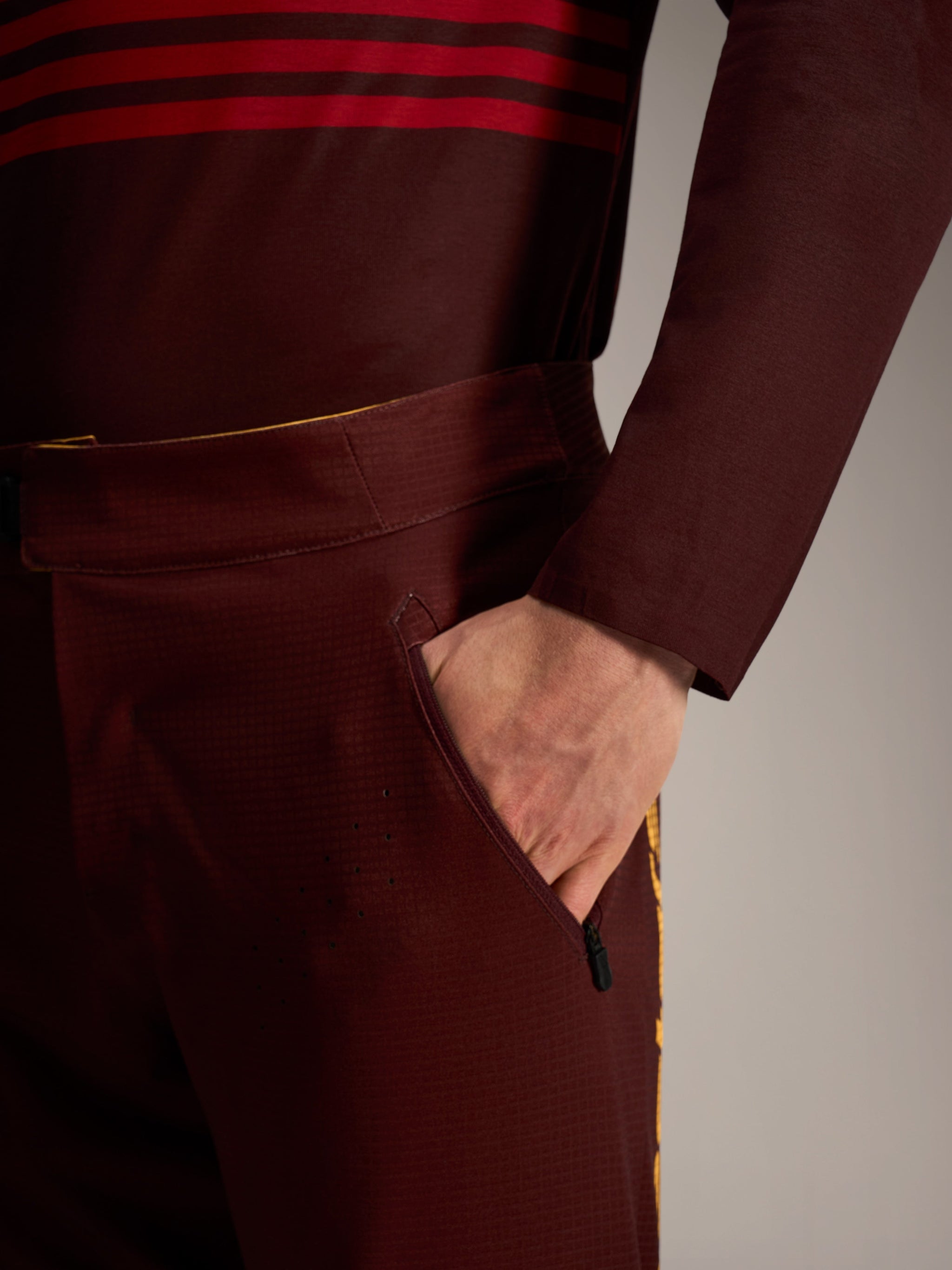 A-Dura Elite Flex Pants in bordeaux, featuring a zippered side pocket, durable ripstop fabric, and laser-cut ventilation.