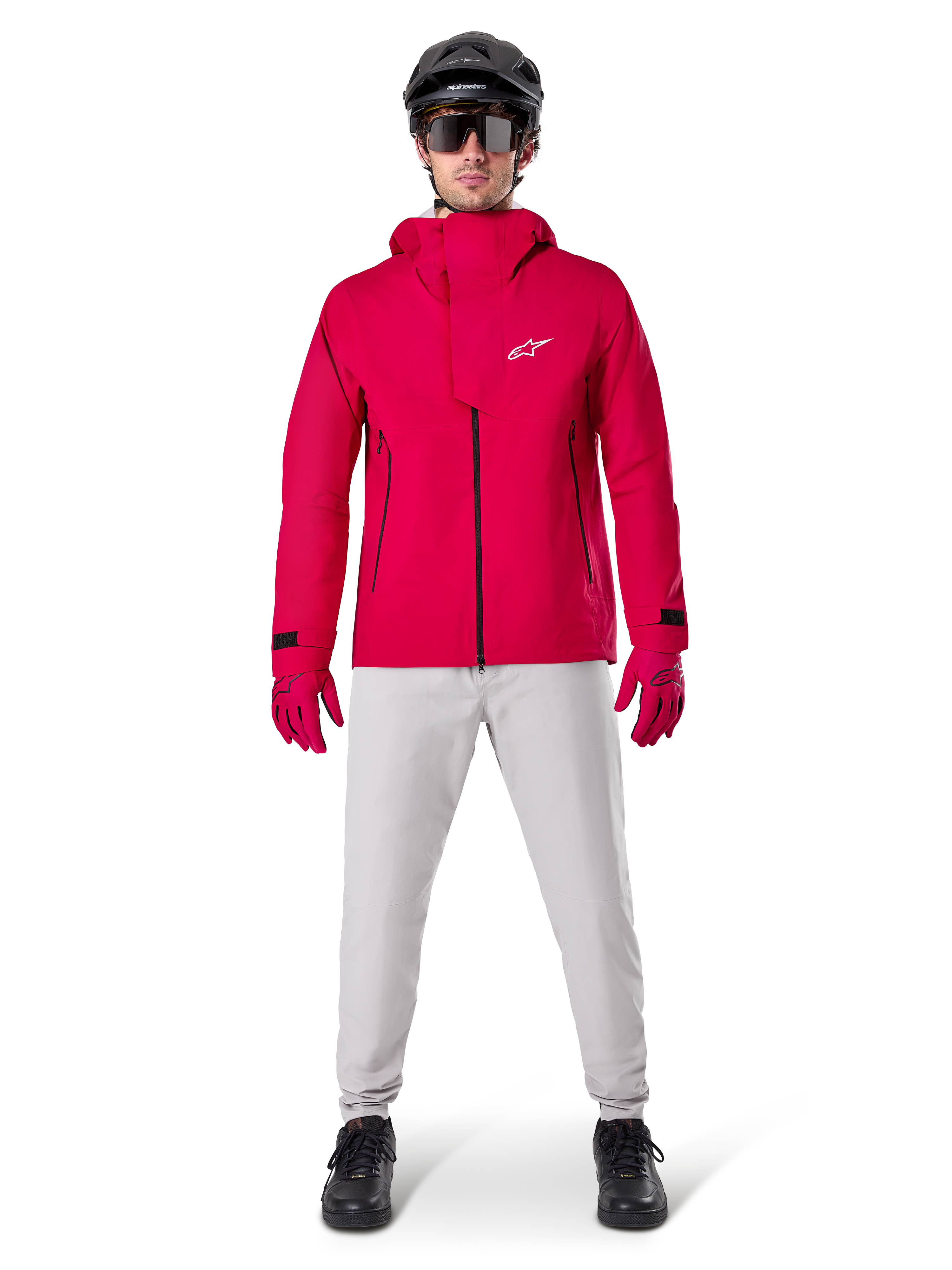 Alpinestars A-Dura Waterproof Pants, MTB Pants, Titanium Gray, worn with a bright red hooded jacket, red gloves, and a black mountain bike helmet, professional waterproof cycling gear for wet trail conditions