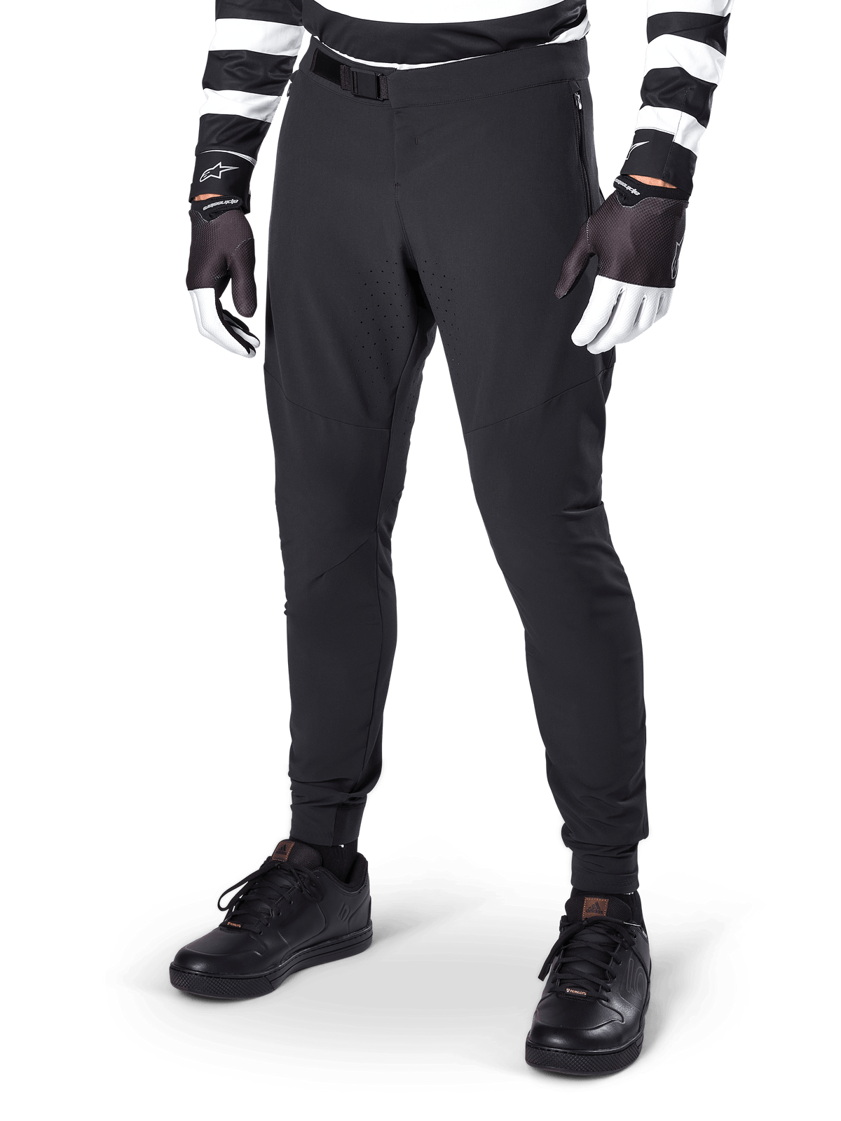 Alpinestars A-Aria Elite Pants, Black Mountain Bike Pants, featuring laser-cut ventilation on thighs and magnetic buckle closure, worn with black and white striped jersey and gloves, performance MTB gear for off-road cycling