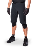 Alpinestars A-Aria Elite Shorts, Black Cycling Shorts, worn with matching black gloves and knee guards, featuring a magnetic buckle and laser-cut perforations, sleek design for off-road mountain biking