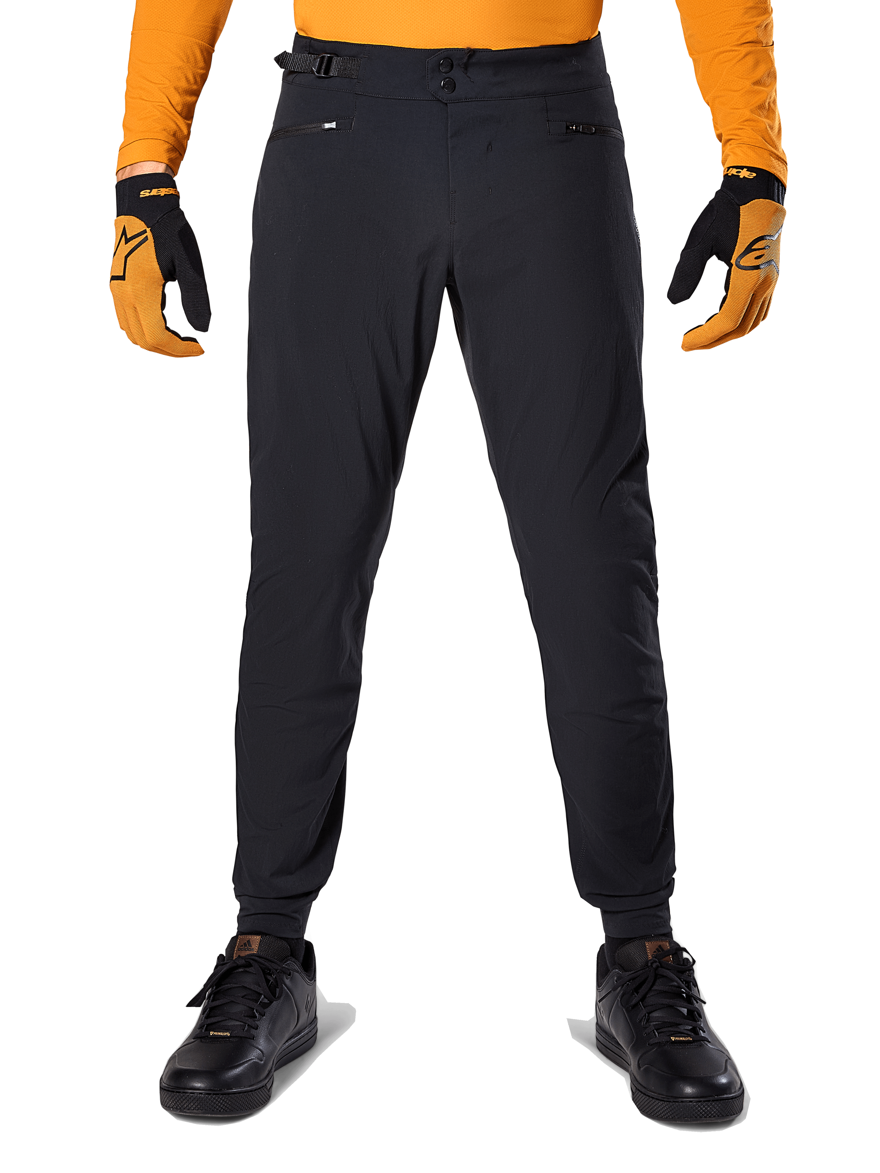 Alpinestars A-Dura Pants, Mountain Bike Pants, Black, worn with an orange long-sleeve jersey and black and orange gloves, featuring a double snap closure and side waist adjusters, durable textile for off-road cycling