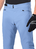Alpinestars A-Dura Pants, MTB Cycling Pants, Infinity Blue, close-up of waist featuring double snap closure and side cinch adjuster, zippered pockets, worn with black Alpinestars gloves
