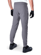 Alpinestars A-Dura Pants, Mountain Bike Pants, Dark Gray, rear view of model wearing the gear, featuring a durable 2-way stretch fabric and elasticated cuffs, coordinated with black gloves and sneakers for a cycling-ready look