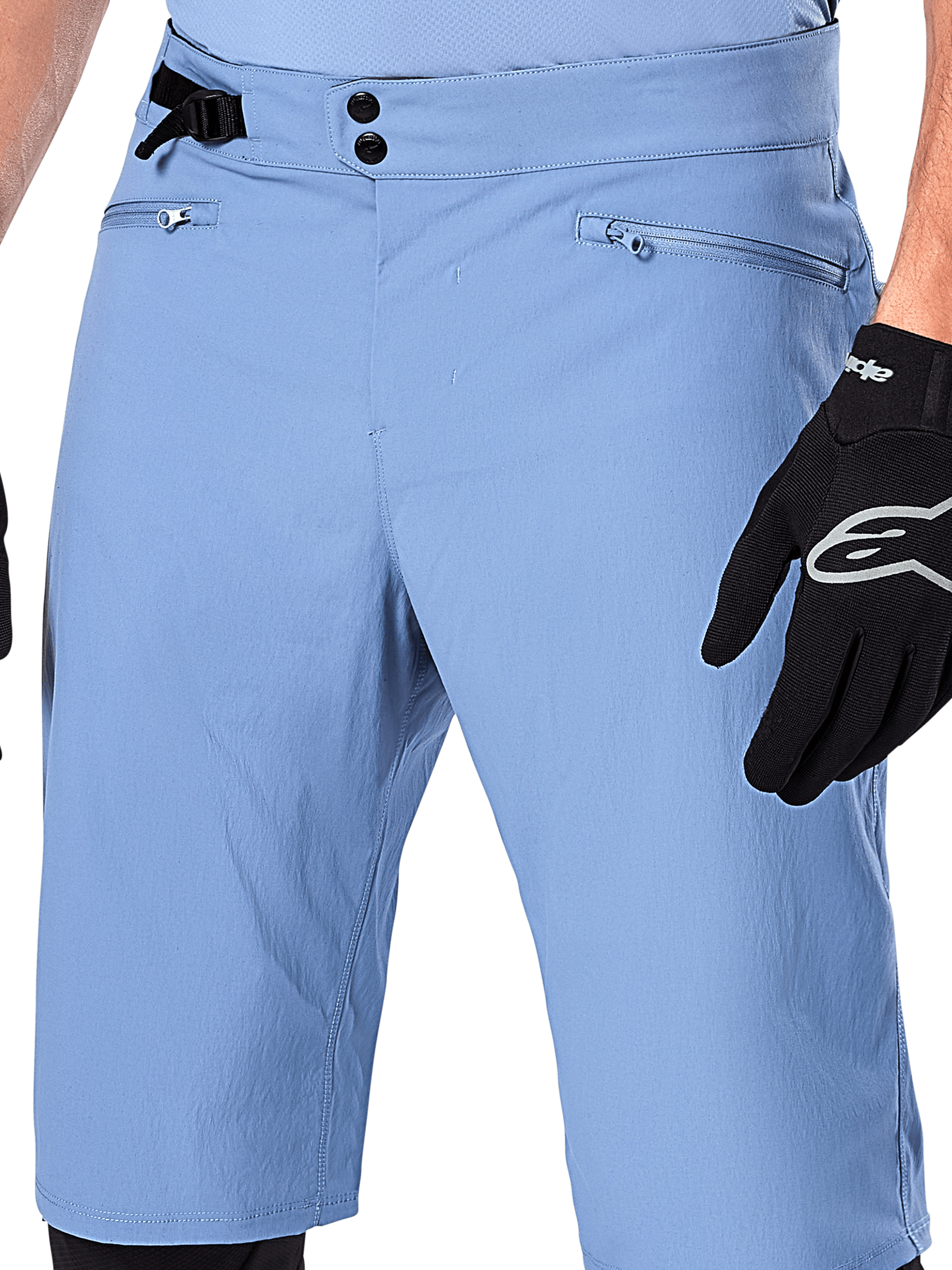 Alpinestars A-Dura Shorts, Infinity Blue mountain bike shorts, close-up of the waist featuring double snap closure, adjustable side cinch, and zippered mesh-lined pockets, worn with a black Alpinestars glove